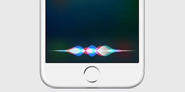Close-up of an iPhone displaying Siri's colorful waveform interface against a white background, showing the voice assistant's visual representation when activated.
