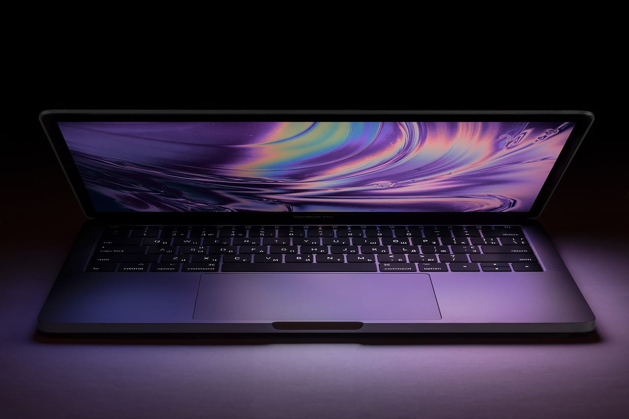 Apple MacBook Pro with colorful screen on a dark background