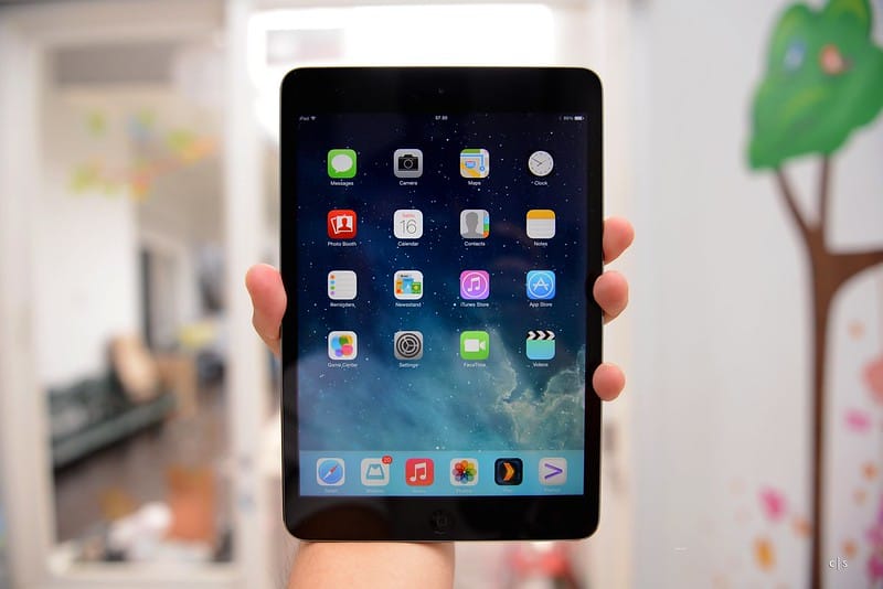 Apple iPad mini with Retina Display showing home screen apps indoors