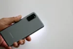 Person holding Samsung Galaxy S20 smartphone showing back panel with Samsung branding and camera module