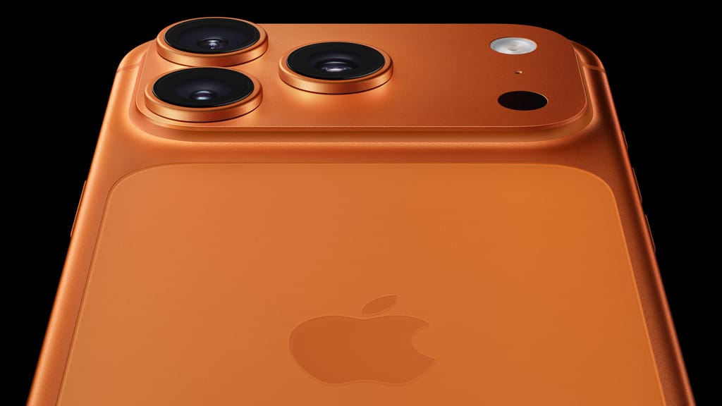 Close-up view of the iPhone 17 Pro's rear camera module featuring three lenses in a triangular arrangement on the copper-gold colored device, showing the premium finish and professional camera system.