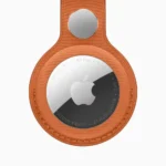 Apple AirTag attached to FineWoven Key Ring in multiple color options including fox orange, midnight purple, navy, moss, and black against white background