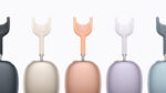 Five AirPods Max 2 headphones displayed side by side showing the full colour lineup from left to right: Midnight, Starlight, Orange, Purple, and Blue