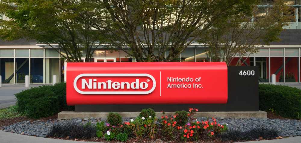 Red Nintendo sign at company headquarters entrance in Redmond Washington showing updated modern branding against landscaped grounds