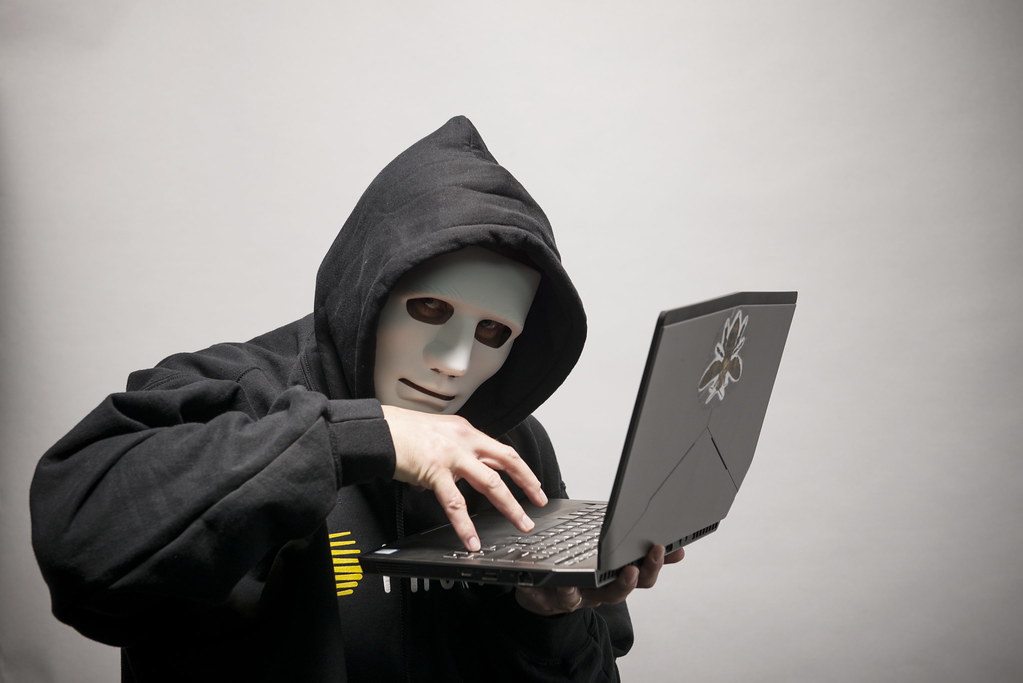 A shadowed hand with digital code overlay representing a cybersecurity threat or hacker activity