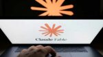 Claude Fable logo displayed on a laptop screen with a person's hand resting on the keyboard and a larger projection of the Anthropic logo visible in the background