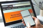 Amazon logo and shopping cart icon on a smartphone screen, representing the company's e-commerce and retail business.