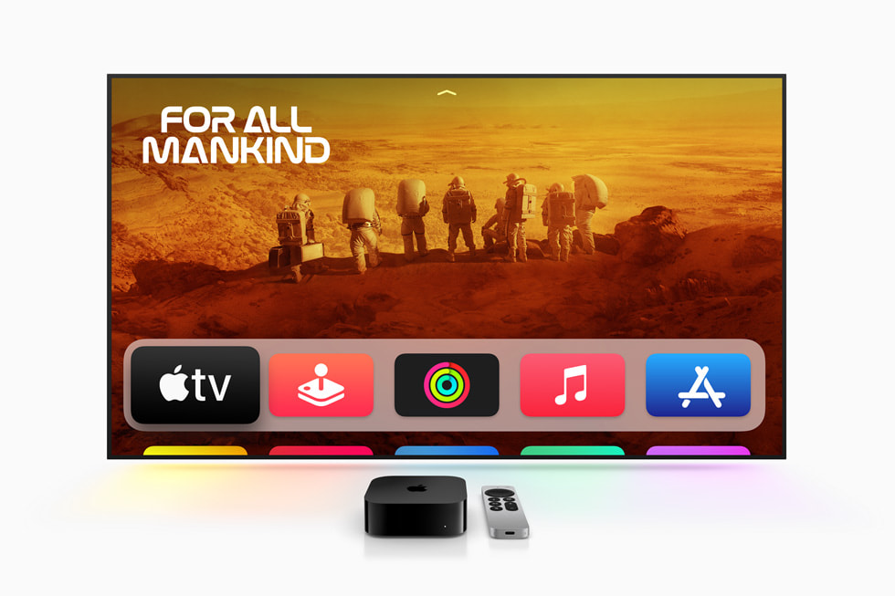 A sleek, black Apple TV 4K set-top box sits on a reflective surface, with the Siri Remote placed next to it. The device's compact design and glossy finish are highlighted against a dark background.